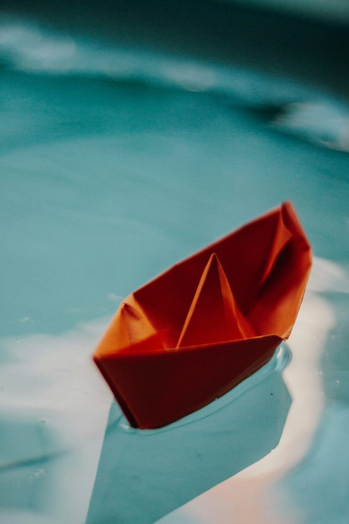 a-paper-boat-floating-on-top-of-a-body-of-water-nfpfi4wwyyk